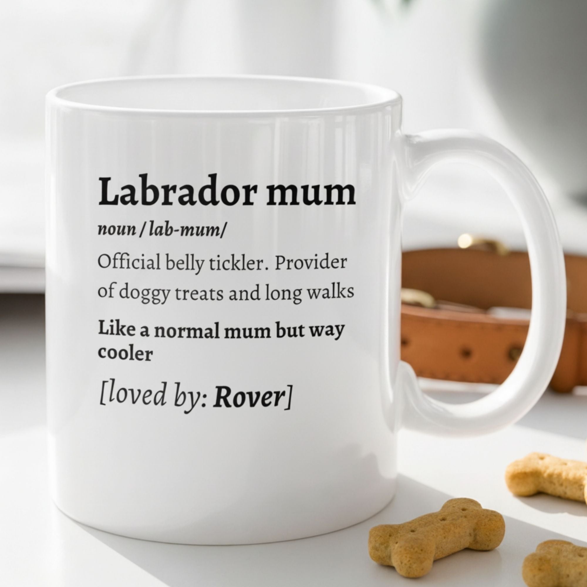 White mug with text about a Labrador mum on a surface with dog treats.