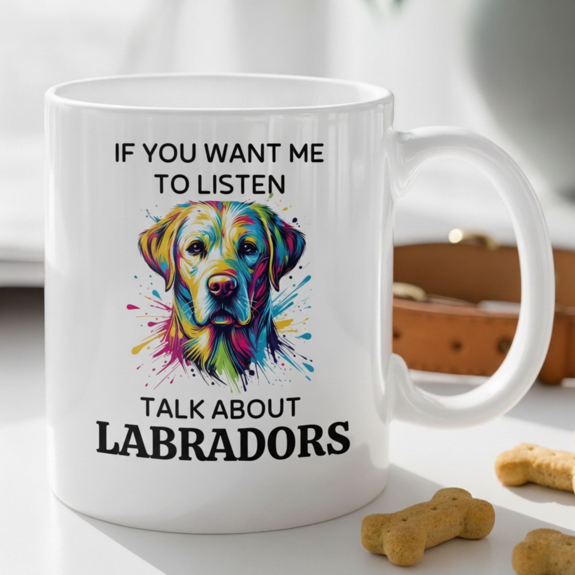 White mug with colorful Labrador illustration and text on a table with dog treats.